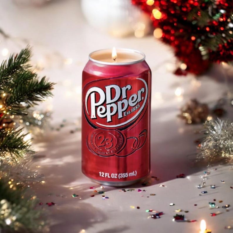 May include: A red Dr Pepper can candle with a lit wick. The can is surrounded by colorful confetti and a festive background.