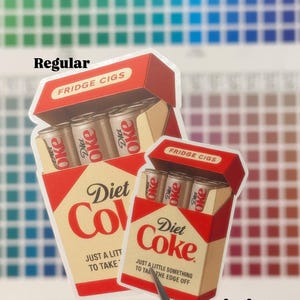K&ouml;nnte beinhalten: Zwei Aufkleber-Designs mit Diet Coke-Dosen im Zigarettenschachtel-Stil. Die Schachteln sind rot und beige mit den Aufschriften "Diet Coke" und "FRIDGE CIGS". Eine Schachtel ist mit "Regular" und die andere mit "Mini" beschriftet.