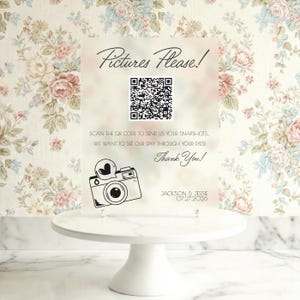 May include: Clear acrylic sign with the text "Pictures Please!" and a QR code, along with a camera illustration. The sign also includes the text "Scan the QR code to send us your snapshots. We want to see our day through your eyes! Thank You!" and the names "Jackson & Jessie 07.27.2026".