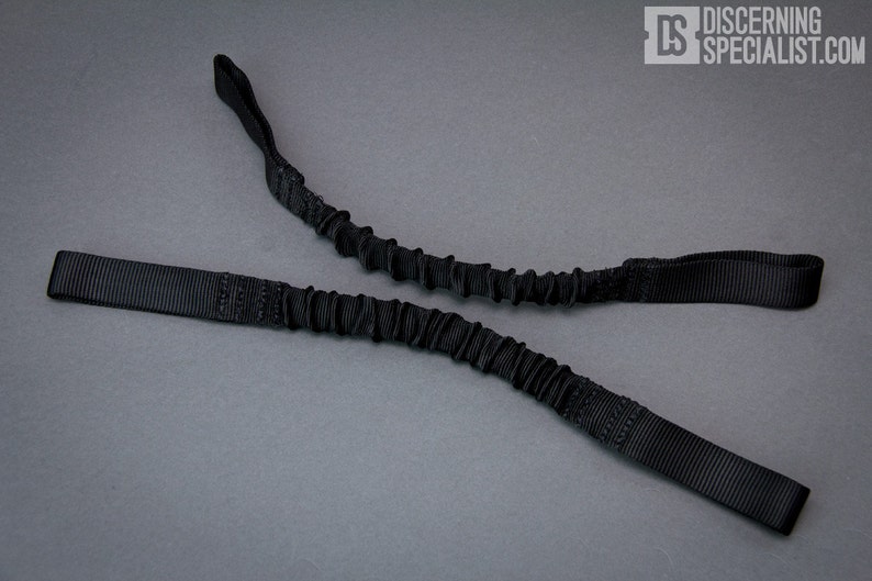 May include: Black bungee cord with two loops on each end. The cord is made of a stretchy material and is designed to be used for a variety of purposes.