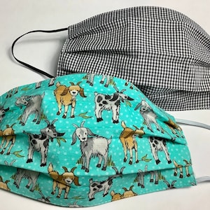 May include: Two face masks, one with a black and white gingham pattern and the other with a turquoise background and a repeating pattern of brown, white, and gray goats.