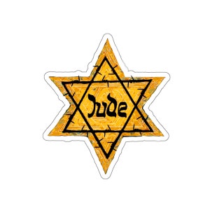 Puede incluir: Una estrella amarilla de seis puntas con alambre de púas alrededor de los bordes. La palabra "Jude" está escrita en negro dentro de la estrella.