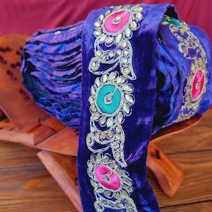 Purple braid on velvet with colored embroidery and rhinestones, traditional decoration of Afghan clothing, baludji, Indian lace.