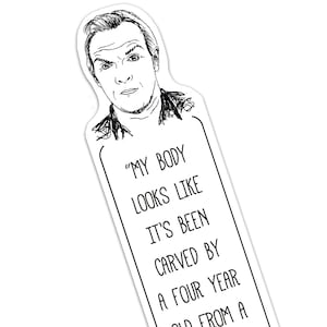 May include: A white bookmark featuring a black and white illustration of a man's face and the quote, "MY BODY LOOKS LIKE IT'S BEEN CARVED BY A FOUR YEAR OLD FROM A". The bookmark is rectangular with a curved top.