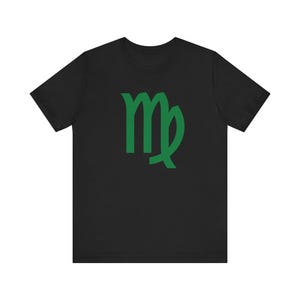 May include: Black t-shirt featuring a green Virgo zodiac symbol. The graphic is centered on the front of the shirt. The short-sleeved tee is made of a soft material.