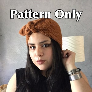 May include: A brown crocheted turban style hat with a knot on top. The hat is worn by a person with long dark hair. The text "Pattern Only" is visible at the top of the image.