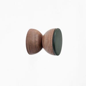 May include: A wooden wall hook with a dark brown finish and a black rubber base.