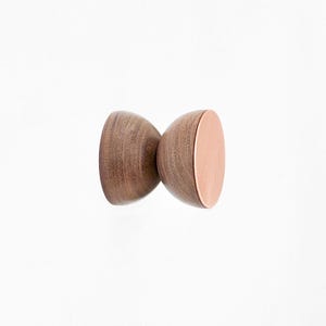 May include: A wooden knob with a copper top. The knob is shaped like a double-ended hourglass.