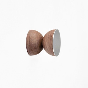 Peut inclure: Un crochet mural en bois avec une forme arrondie en sablier. Le crochet est en bois brun foncé avec un motif de grain naturel. Le crochet a une base circulaire blanche.