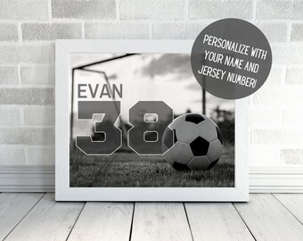 May include: Black and white photo of a soccer ball on a grassy field with a goal in the background. The name "Evan" and the number "38" are superimposed on the image.