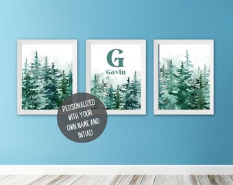 May include: Three framed watercolor prints featuring a forest scene with green pine trees. The middle print has a large letter "G" and the name "Gavin" below it.