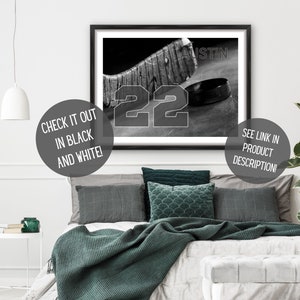 May include: Black and white photo of a hockey stick and puck with the number 22 and the word "AUSTIN" printed on the image.