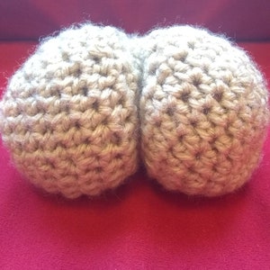 May include: Two beige crocheted balls, possibly for a craft project or home decor.