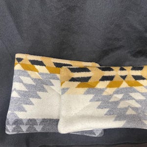 May include: Two decorative throw pillows with a geometric pattern in shades of gray, white, black, and yellow.