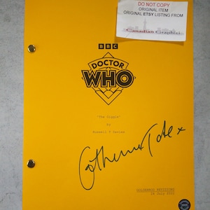 May include: A yellow script cover for the Doctor Who episode "The Giggle" by Russell T Davies. The cover features the Doctor Who logo and a signature from Catherine Tate.
