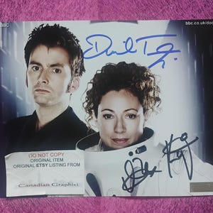 May include: A rectangular promotional photograph featuring David Tennant and Alex Kingston from Doctor Who, with blue ink autographs from both actors. The image includes the text BBC, bbc.co.uk/doctor, and a white label reading DO NOT COPY.
