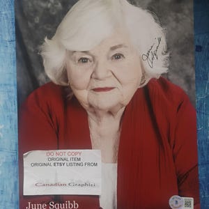 Peut inclure: Un portrait de June Squibb, avec sa signature. Elle porte un haut rouge et a les cheveux blancs. L'image comprend le texte "DO NOT COPY ORIGINAL ITEM ORIGINAL ETSY LISTING FROM Canadian Graphici".