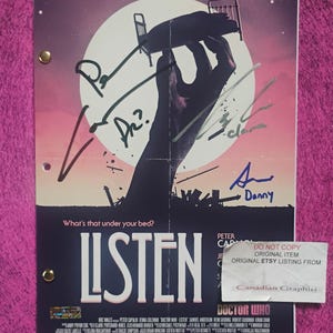Pode incluir: Uma capa de roteiro de Doctor Who Listen com uma mão grande alcançando uma cama contra um fundo de lua cheia. O pôster inclui o texto What's that under your bed? e Listen, juntamente com várias assinaturas em tinta preta e azul.