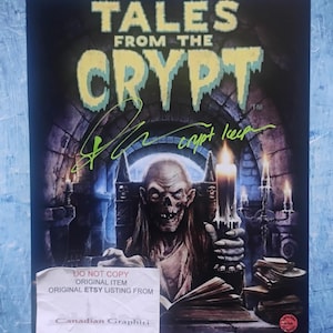 May include: A print of "Tales From The Crypt" with a ghoulish figure holding a candle. The title is in yellow dripping font. The print is signed in green ink. A sticker at the bottom reads "DO NOT COPY ORIGINAL ITEM ORIGINAL ETSY LISTING FROM Canadian Graphiti."
