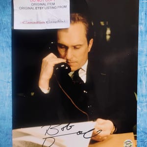 May include: A photograph of a man in a suit holding a telephone receiver to his ear. The image includes a signature and the text "DO NOT COPY ORIGINAL ITEM ORIGINAL ETSY LISTING FROM Canadian Graphiti."