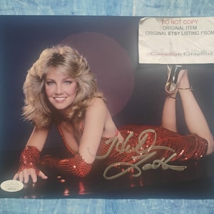 Może przedstawiać: Zestaw trzech ceramicznych kubków z nakrapianym, matowym wykończeniem. Kubki są w odcieniach kremu, jasnoszarym i ciemnoszarym. Każdy kubek ma prosty, minimalistyczny design i zaokrąglony uchwyt.