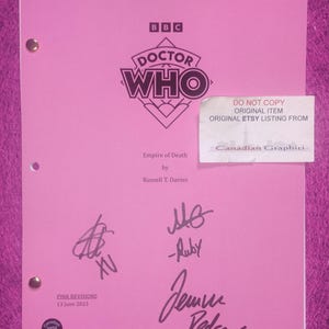 Pode incluir: Um roteiro rosa de Doctor Who intitulado Empire of Death por Russell T. Davies, datado de 13 de junho de 2023. A capa apresenta o logotipo da BBC Doctor Who, três assinaturas em tinta preta e um adesivo branco que diz DO NOT COPY ORIGINAL ITEM ORIGINAL ETSY LISTING FROM Canadian Graphiti.