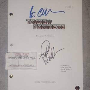 Puede incluir: Una página de guion blanca para el episodio Transport To Oblivion de Transformers, fechada el 6/4/84, con dos firmas en tinta azul y negra. El documento incluye el texto Marvel Productions, Ltd., MP #700-01 y los créditos de los escritores Dick Robbins y Bryce Malek.