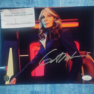 May include: A signed photograph featuring a woman in a dark blue suit with a white collar. The image has a signature in silver ink and a sticker that reads "DO NOT COPY ORIGINAL ITEM ORIGINAL ETSY LISTING FROM Canadian Graphiti."