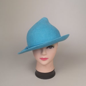 May include: A bright blue felt hat with a pointed crown and a wide brim. The hat is angled on a mannequin head.