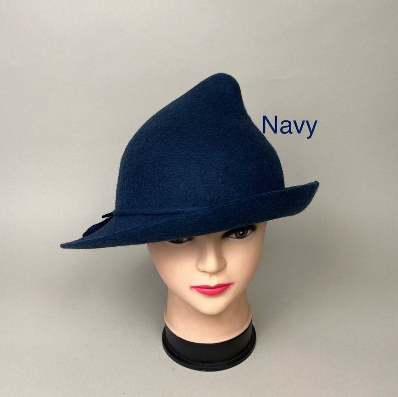 May include: A navy blue felt hat with a pointed crown and a wide brim. The hat is sitting on a mannequin head.