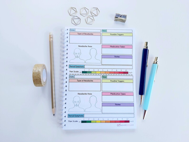 May include: A spiral bound notebook with a pink, yellow, and blue cover. The notebook has a section for tracking headaches, including the type of headache, possible triggers, medication taken, and notes. There is also a section for tracking period symptoms, including a pain scale.