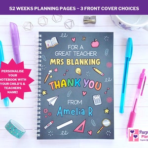 May include: A black spiral notebook with a chalkboard design. The cover features colorful illustrations of school supplies, a heart, a star, and a paper airplane. The text on the cover reads "For a Great Teacher Mrs. Blanking Thank You From Amelia R".