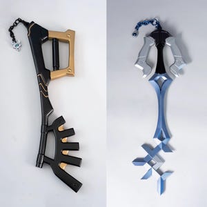May include: Two decorative keyblade props. One is black and gold with a chain and charm. The other is silver and blue with a chain. Both are designed with intricate details and are likely for cosplay or display.