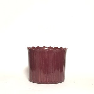 Könnte beinhalten: Ein burgunderfarbener Plastiktopf mit einem gewellten Rand und vertikalen Rippen.