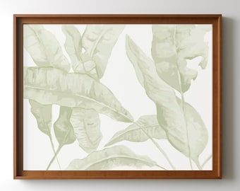 Op de afbeelding: Een ingelijst druk met een aquarel-achtige illustratie van groene tropische bladeren op een witte achtergrond.