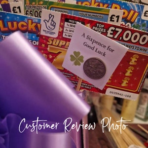 Customer review photo showing a lucky sixpence keepsake included in a scratch card bouquet.