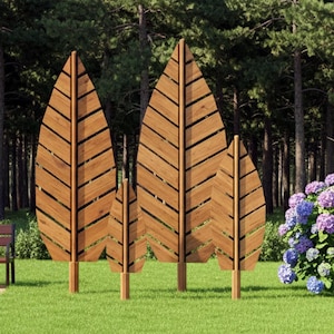 Può includere: Quattro schermi decorativi in legno a forma di foglia di diverse dimensioni si ergono su un prato verde. Gli schermi sono in legno marrone chiaro con un motivo a spina di pesce. Una panchina e un cespuglio con fiori blu e viola sono sullo sfondo.