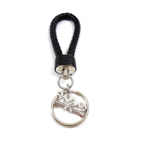 May include: Black leather keychain with a silver charm featuring the year 2019 and a graduation cap.