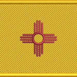 May include: Embroidered patch featuring the New Mexico state flag. The patch has a gold border and a gold background with a diagonal weave pattern. The central design is a red Zia symbol, a Native American sun symbol.