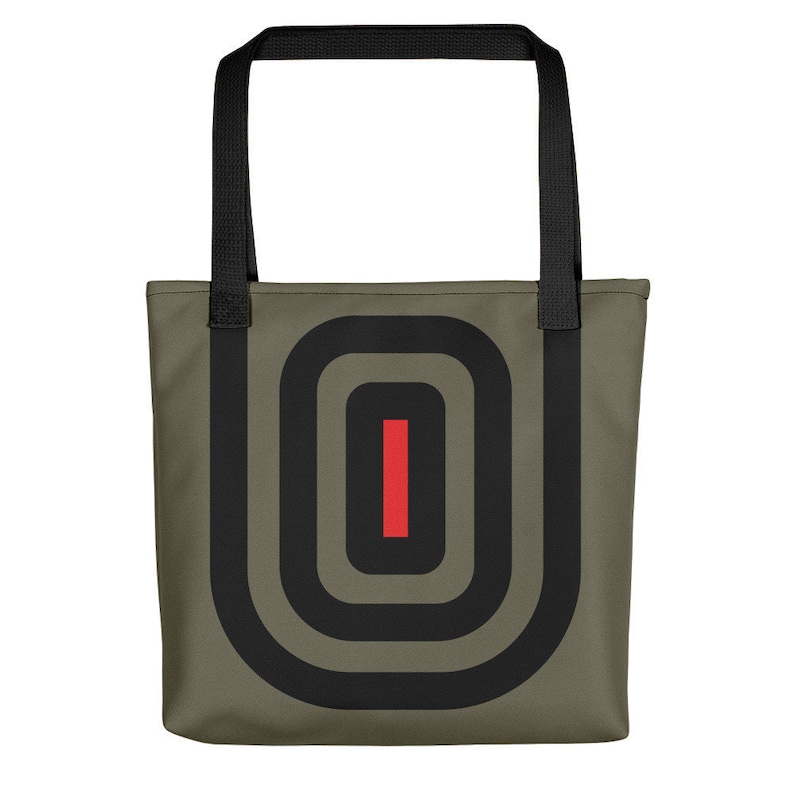 May include: A green canvas tote bag with black straps and a black and red geometric design.