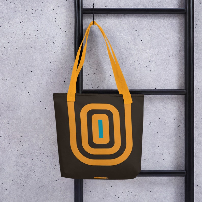 May include: A brown tote bag with yellow and blue geometric designs. The bag has two yellow straps.