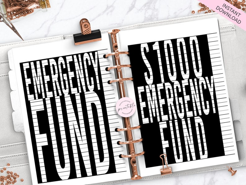 May include: A printable planner page with black and white text that reads "Emergency Fund" and "$1000 Emergency Fund". The text is on a white background with black lines.