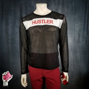 May include: Black mesh long-sleeved shirt with a white band across the chest and the word "Hustler" in red letters.