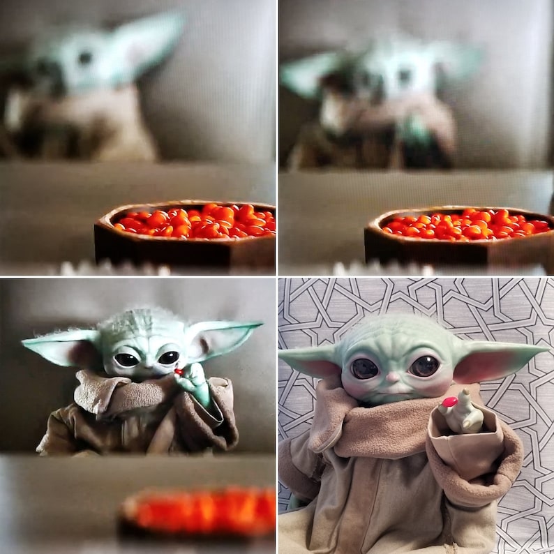 May include: A plush Grogu doll, also known as Baby Yoda, is shown holding a red object. The doll has large black eyes, green skin, and large ears. It is wearing a tan robe. A wooden bowl filled with orange-red candies is in the background.