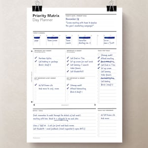Peut inclure: Un agenda quotidien bleu et blanc avec une matrice de priorit&eacute; pour organiser les t&acirc;ches. L'agenda est dat&eacute; du 24 novembre et comprend une liste de t&acirc;ches pour la journ&eacute;e, notamment "Appeler Fred pour les tuiles", "Mettre en place un scrum pour la semaine prochaine", "Appeler Sammy/Lancer la commande de fleurs", et "Appeler Elizabeth!!!". L'agenda comprend &eacute;galement une liste de t&acirc;ches pour le lendemain, notamment "Site Web UI/UX Promo" et "D&eacute;placer le bureau".