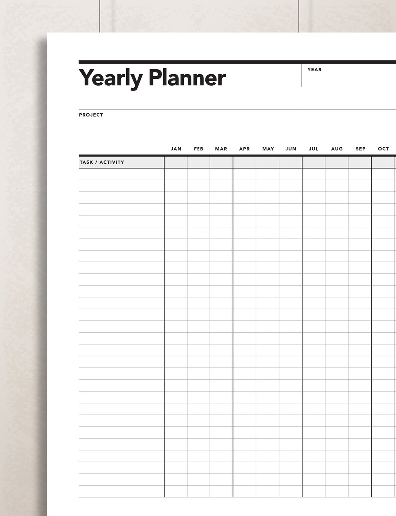 Pode incluir: Um planejador anual preto e branco com um layout de grade. O planejador tem colunas para cada m&ecirc;s do ano, come&ccedil;ando em janeiro e terminando em outubro. O planejador tamb&eacute;m tem uma se&ccedil;&atilde;o para projeto e tarefa/atividade.