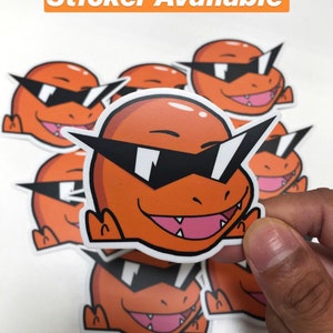 May include: A set of orange and black cartoon stickers featuring a character with sunglasses. The character is wearing sunglasses and has a toothy grin. The text "Charmander Squad Sticker Available" and "Check Out Our Shop!" are visible in the image.