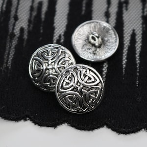 May include: Three silver buttons with a Celtic knot design. The buttons are round and have a raised design.