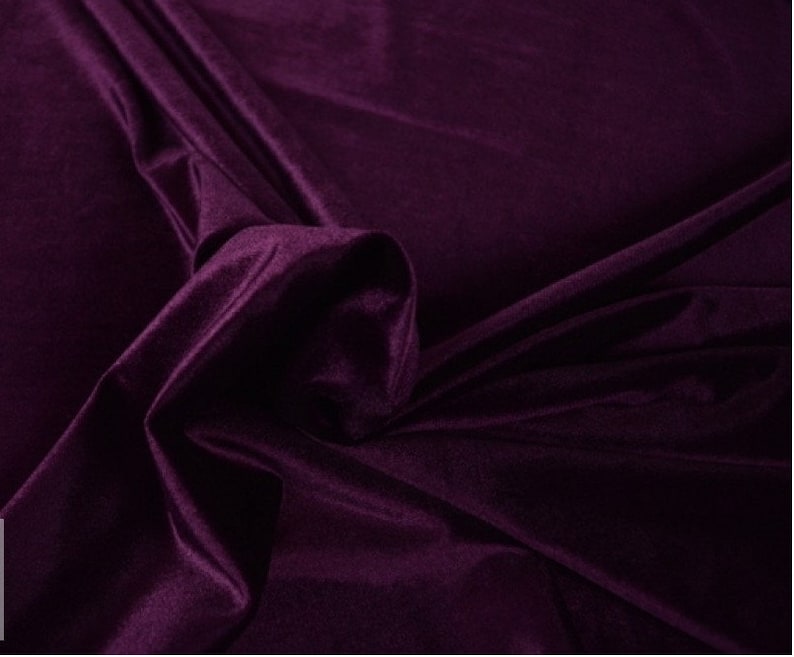 May include: A close-up of a deep purple velvet fabric. The fabric is soft and luxurious, with a subtle sheen.