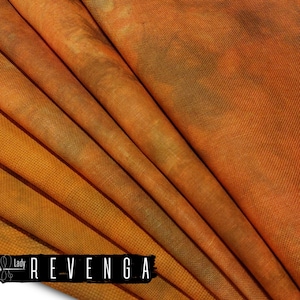 Op de afbeelding: Close-up van gevouwen oranje stof met een getextureerde weefsel. De stof heeft donkerdere bruine en groene accenten, waardoor een gevlekt effect ontstaat. De tekst "Lady REVENGA" wordt weergegeven in een zwarte rechthoek aan de onderkant.